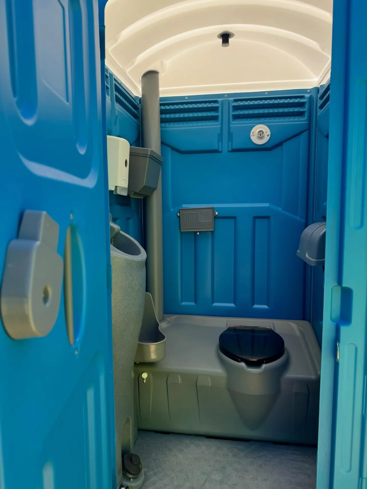 Blue standard portable restroom interior with toilet and urinal